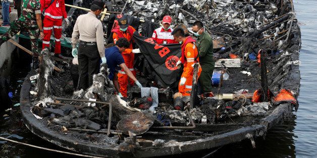 ATTENTION EDITORS - VISUAL COVERAGE OF SCENES OF INJURY OR DEATHRed Cross and rescue workers prepare to remove the remains of a victim after a fire ripped through a boat carrying tourists to islands north of the capital, at Muara Angke port in Jakarta, Indonesia January 1, 2017. REUTERS/Darren WhitesideTEMPLATE OUT
