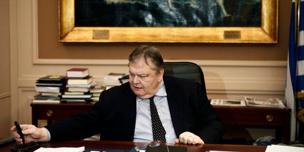 Greece's Deputy Prime Minister, Foreign Minister and co-ruling PASOK Socialist party leader Evangelos Venizelos looks at his mobile phone before an interview with Reuters at the foreign ministry in Athens January 20, 2015. Greece's Socialist PASOK party could support a government led by the radical leftist Syriza party as part of a wider pro-euro alliance to steer the country out of its bailout program, PASOK leader Venizelos told Reuters. Picture taken January 20, 2015. To match Interview GREEC