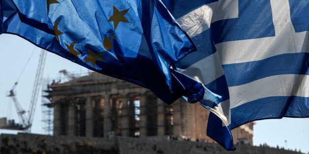 A European Union (EU) flag, left, flies beside a Greek national flag in front of the Parthenon temple on Acropolis Hill in Athens, Greece, on Wednesday, July 8, 2015. The European Union set a Sunday deadline to reach a deal with Greece on a financial rescue in exchange for austerity measures and economic reforms. Photographer: Yorgos Karahalis/Bloomberg via Getty Images