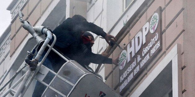 TURKEY OUTThis picture obtained from Dogan News Agency shows protesters breaking and removing the logo on the facade of the offices of pro-Kurdish Peoples' Democratic Party (HDP) following a suicide car bombing on December 17, 2016 in Kayseri, central Turkey.Thirteen Turkish soldiers were killed and dozens more wounded on December 17 in a suicide car bombing targeting off-duty conscripts blamed on Kurdish militants, the latest in a string of attacks to rock Turkey in recent months. Forty-eight s