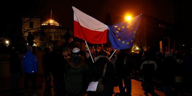 Demonstrators hold Polish and EU flags during a protest outside the Parliament building in Warsaw, Poland December 17, 2016. REUTERS/Kacper Pempel