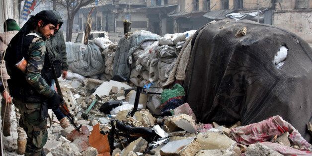 Syrian government forces walk in Aleppo's newly captured Al-Kalasseh neighbourhood in the eastern part of the war torn city on December 13, 2016.After weeks of heavy fighting, regime forces were poised to take full control of Aleppo, dealing the biggest blow to Syria's rebellion in more than five years of civil war. / AFP / George OURFALIAN (Photo credit should read GEORGE OURFALIAN/AFP/Getty Images)