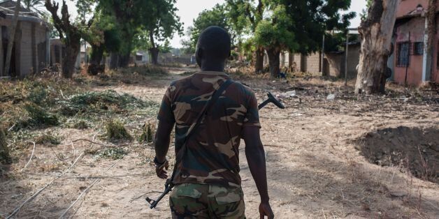 A nigerian soldier patrols in the streets of Bama in northeast Nigeria on December 8, 2016.The houses are burnt-out shells, and charred cars and petrol pumps line the roads in the once-bustling Nigerian trade hub of Bama before it was razed by Boko Haram jihadists, know 85% is destroyed. The camp now houses a little over 10,000 people who either escaped or survived the seven months under Boko Haram rule. The conflict with Boko Haram in northeast Nigeria has displaced more than 2.6 million people. / AFP / STEFAN HEUNIS (Photo credit should read STEFAN HEUNIS/AFP/Getty Images)