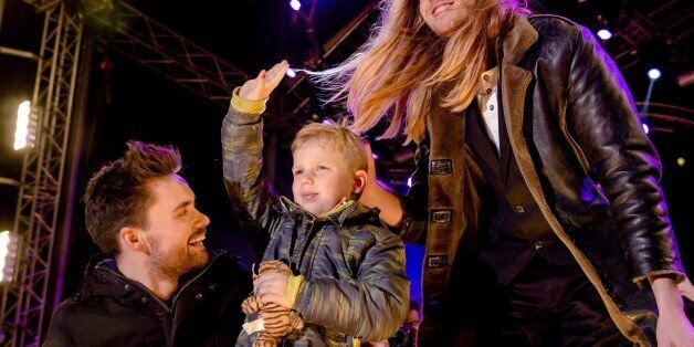 Dutch 3FM DJ's Domien Verschuuren (L) and Frank van der Lende show together with 6 year old Tijn Kolsteren the amount of money (8,744,131 euros) they have raised at the House of Glass (Het Glazen Huis) of Serious Request in Breda, on December 24, 2016. Serious Request is a annual project by Dutch radio station 3FM in which they collect money for projects of the Red Cross, this year to prevent children dying from pneumonia. During the project, three DJs live in a house of glass for six days without eating anything, instead drinking special juice to stay fit. Tijn is terminally ill (he suffers from brain cancer) and had one last wish. He wanted to raise as much money as possible to help other children. / AFP / ANP / Sander Koning / Netherlands OUT (Photo credit should read SANDER KONING/AFP/Getty Images)