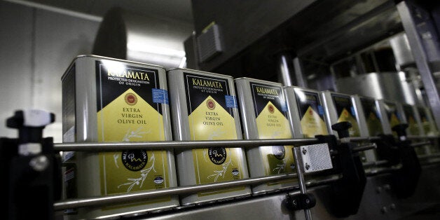 Cans of extra virgin olive oil pass along the automated production line at the bottling and processing plant operated by the Messina Union in Kalamata, Greece, on Friday, Dec. 4, 2015. The latest list of Greek reforms, which needs to be implemented by Dec. 11, includes measures ranging from new salary scales for civil servants, to the transfer of non-performing loans management to funds and non-banking ventures. Photographer: Kostas Tsironis/Bloomberg via Getty Images