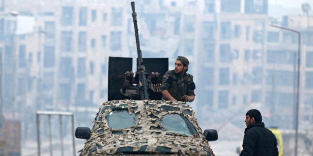 A Free Syrian Army fighter sits on a camouflaged vehicle mounted with a weapon in a rebel-held area of Aleppo, Syria December 12, 2016. REUTERS/Abdalrhman Ismail