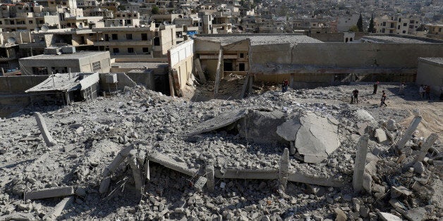 People inspect the damage at a site hit by overnight airstrikes in the town of Kafr Takharim, in Idlib Governorate, Syria October 24, 2016. REUTERS/Ammar Abdullah