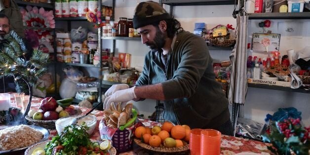 Chef Talal Rankoussi puts final touch to the prepared meal in the 'cafe Rits' in Ritsona refugee camp, some 80 km north of Athens on December 21, 2016. Before braving a 'trip of death' to escape Syria, Talal Rankoussi was a chef in a Damascus restaurant considered the largest in the world.Bawabet Al Dimashq -- Damascus Gate -- still holds that distinction in the Guinness Book of Records as it can seat over 6,000 people.So when 41-year-old Talal was asked by a US benefactor to spice up the meal