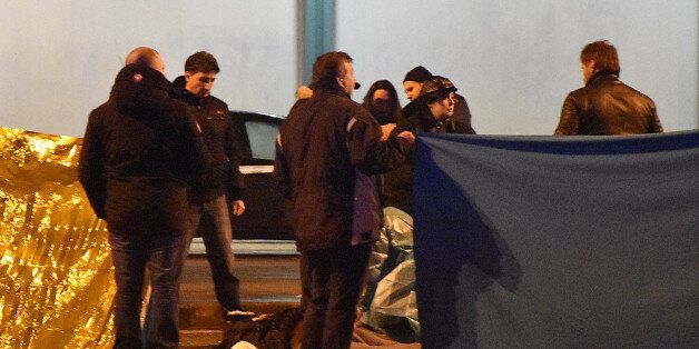 Italian police and forensics experts gather around the body of suspected Berlin truck attacker Anis Amri after he was shot dead in Milan on December 23, 2016. The Tunisian man suspected of carrying out the deadly Berlin truck attack at the Christmas market was shot dead by police in Milan on December 23, Italy's interior minister Marco Minniti said. The minister told a press conference in Rome that Anis Amri had been fatally shot after firing at two police officers who had stopped his car for a