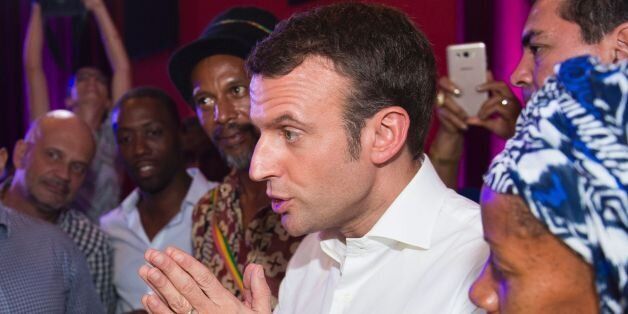 Former French Economy Minister, founder and president of the political movement 'En Marche !' and candidate for the 2017 presidential elections Emmanuel Macron (2R) speaks with people during his visit in Fort-de-France on the French Caribbean island of Martinique, on December 19, 2016. / AFP / Lionel CHAMOISEAU (Photo credit should read LIONEL CHAMOISEAU/AFP/Getty Images)