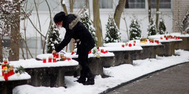 A girl places a candle on a wall after commemoration ceremony in front of the Albertville Realschule (school) in Winnenden, March 11, 2010. A 17-year old gunman went on a shooting spree at his former secondary school, the Albertville-Realschule in Winnenden in southwest Germany on March 11, 2009, killing up to 15 people before dying himself in a shootout with police. REUTERS/Johannes Eisele (GERMANY - Tags: POLITICS ANNIVERSARY)