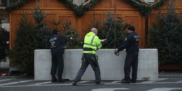 BERLIN, GERMANY - DECEMBER 22: Police install concrete blocks as a security barrier on the periphery of the reopened Breitscheidplatz Christmas market, where three days ago a truck plowed into the market, killed 12 people and injured dozens in a terrorist attack on December 22, 2016 in Berlin, Germany. The Breidscheidplatz Christmas market is reopening today, though its small amusement rides and bright lights displays will remain shut off in a sign of continuing mourning for the attack victims. Meanwhile police have launched a European-wide manhunt for Anis Amri, a 24-year-old Tunisian man they suspect of having driven the truck. (Photo by Sean Gallup/Getty Images)