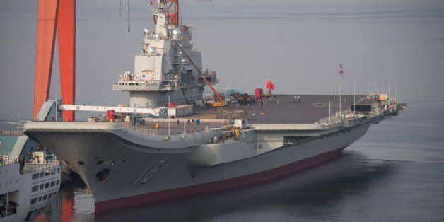 To go with China-Japan-US-maritime-defence,FOCUS by Sebastien BlancThis photo taken on July 6, 2014 shows the Chinese aircraft carrier Liaoning docked at the seaport city of Dalian in northeast China's Liaoning province. The 300-metre (1,000-foot) Liaoning -- a Soviet-era vessel Beijing bought from Ukraine -- was commissioned in September 2012, and officers have acknowledged that it is not yet ready for combat, with naval fighter pilots taking years to train. CHINA OUT AFP PHOTO (Photo credit should read STR/AFP/Getty Images)