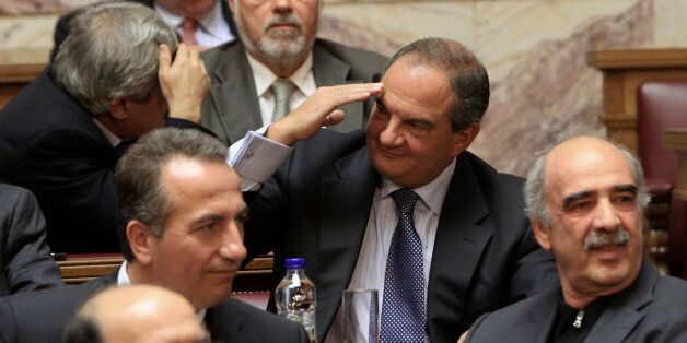 Former conservative Prime Minister Costas Karamanlis (C) greets a colleague during a New Democracy party parliamentary group meeting in Athens November 2, 2011. REUTERS/Panagiotis Tzamaros (GREECE - Tags: POLITICS BUSINESS)
