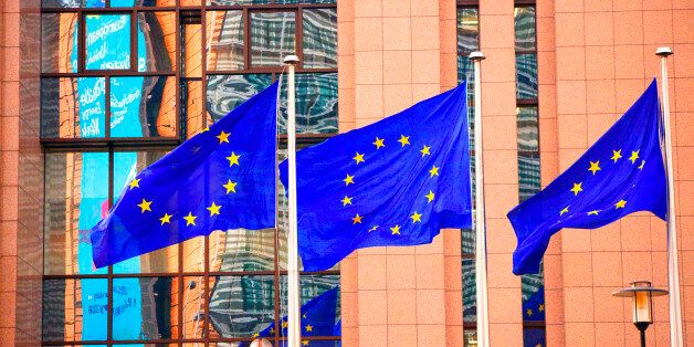Belgium, Wallonia, Brussels; Three flags carrying the European Union emblem in front of the E.U headquarters