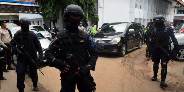 Armed Indonesian elite police commandos secure the exit at the court house for the departure of a vehicle (background R) carrying French drug trafficker Serge Atlaoui in Tangerang on March 11, 2015 following a court hearing on judicial review against his death sentence. Atlaoui is among a group of drug convicts, including nationals from Australia, Brazil, the Philippines, Ghana and Nigeria, who face imminent execution by firing squad in Nusakambangan prison island after recently losing their app
