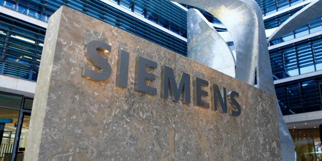 FILE - In this June 24, 2016 file photo the logo of German industrial conglomerate Siemens is pictured prior to the opening ceremony at the new headquarters in Munich, Germany. Siemens AG raised its profit forecast for the year Thursday, Aug. 4, 2016 as new orders jumped and quarterly profits beat expectations. (AP Photo/Matthias Schrader, file)