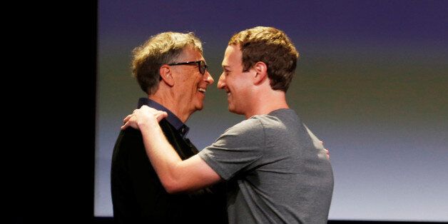 Philanthropist Bill Gates (L) embraces Facebook's Mark Zuckerberg during an announcement of the Chan Zuckerberg Initiative to