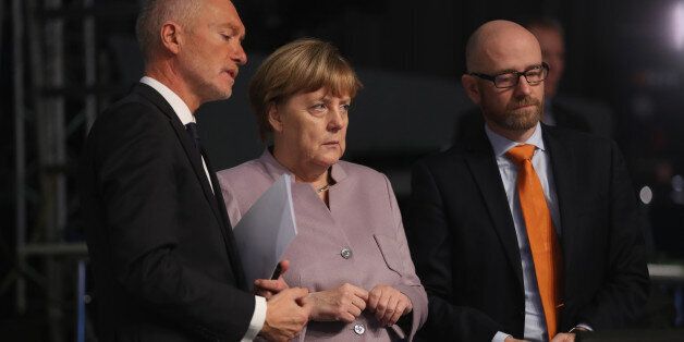 ESSEN, GERMANY - DECEMBER 05: German Chancellor and Chairwoman of the German Christian Democrats (CDU) Angela Merkel, flanked by CDU spokesman Peter Tauber (R) and CDU managing director Klaus Schueler, views the hall where the CDU will hold its annual federal congress beginning tomorrow on December 5, 2016 in Essen, Germany. Over 1,000 CDU delegates will meet to debate and vote on the party's course for next year following the recent announcement by Merkel that she will run for a fourth term as chancellor in federal elections scheduled for next September. (Photo by Sean Gallup/Getty Images)