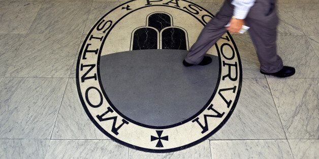 A man walks on a logo of the Monte Dei Paschi Di Siena bank in Rome, Italy September 24, 2013. REUTERS/Alessandro Bianchi/File Photo