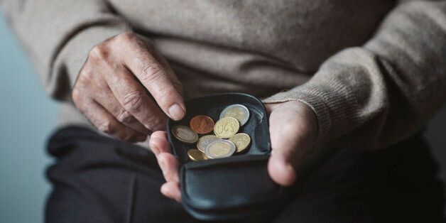 An elderly man look for some money from his wallet