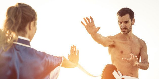 couple training martial arts on the beach. concept about sport and people