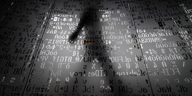 TOPSHOT - A picture taken on October 17, 2016 shows an employee walking behind a glass wall with machine coding symbols at the headquarters of Internet security giant Kaspersky in Moscow. / AFP / Kirill KUDRYAVTSEV / TO GO WITH AFP STORY BY Thibault MARCHAND (Photo credit should read KIRILL KUDRYAVTSEV/AFP/Getty Images)