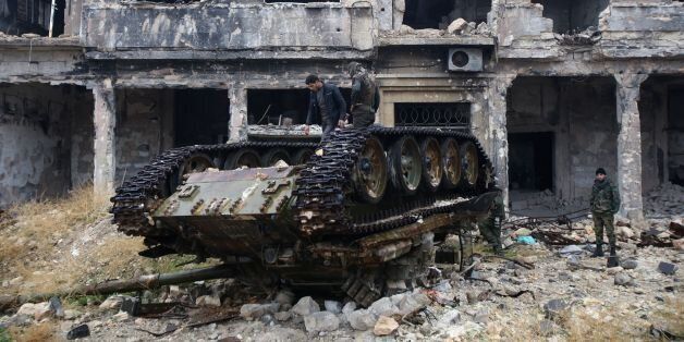 Syrian pro-government forces stand on a tank near the ancient Umayyad mosque in the old city of Aleppo on December 13, 2016, after they captured the area.After weeks of heavy fighting, regime forces were poised to take full control of Aleppo, dealing the biggest blow to Syria's rebellion in more than five years of civil war. / AFP / Youssef KARWASHAN (Photo credit should read YOUSSEF KARWASHAN/AFP/Getty Images)