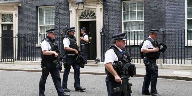 Armed police pass number 10 Downing Street in London, U.K., on Friday, July 15, 2016. Theresa May will visit Edinburgh on Friday, her first foray outside of London since becoming U.K. prime minister, to deliver in person a pledge to govern in the interests of all Scots and damp their call for independence following the Brexit vote. Photographer: Chris Ratcliffe/Bloomberg via Getty Images