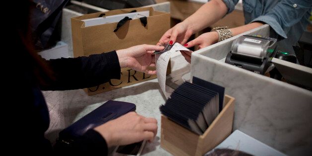 An employee hands a credit card and receipt to a customer at J. Crew Group Inc.'s new women's store inside the International Finance Centre (IFC) mall in Hong Kong, China, on Thursday, May 22, 2014. J. Crew, the retail chain that opened its first Asian stores today, plans to expand its international push with outlets in continental Europe and will be scouting for locations in Paris. Photographer: Brent Lewin/Bloomberg via Getty Images