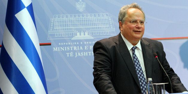 Greek Foreign Minister, Nikos Kotzias speaks at a news conference while hundreds of the Cham community members, expelled from northwestern Greece during World War II after Athens claimed they had collaborated with the country's German occupiers, hold a protest outside, Tirana Monday, June 6, 2016. Four issues have turned bilateral ties sour between the neighbors: the Chams' claims on their confiscated property; the technical state of war still in place since then-fascist Italy attacked Greece through Albania in 1940; an unresolved maritime dispute and Greek claims of discrimination against the ethnic Greek minority in Albania. (AP Photo/Hektor Pustina)