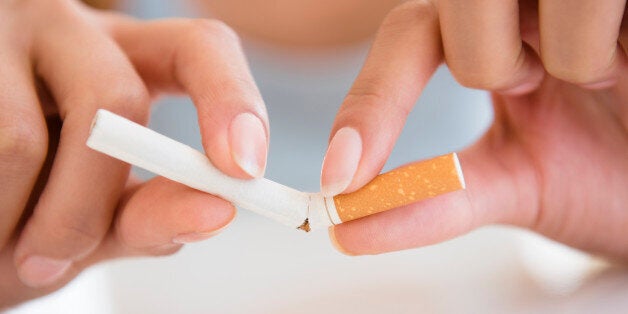 Close up of Hispanic woman breaking cigarette