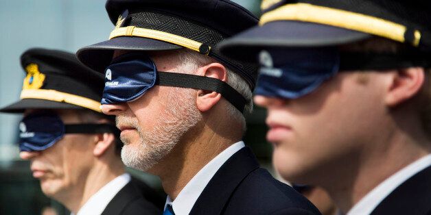 COLOGNE, GERMANY - MAY 14: Pilots and airline personnel protest wearing sleeping masks against proposed new regulations outside the European Aviation Safety Agency (EASA) on May 14, 2012 in Cologne, Germany. The pilots argue the new regulations would create safety risks by exposing them to overly long work hours and that it would lead to fatigue. (Photo by Carsten Koall/Getty Images)