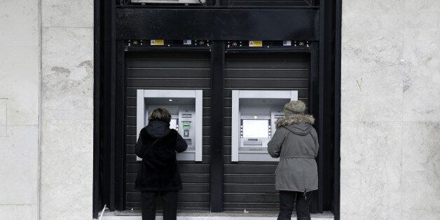 Customers withdraw cash from automated teller machines (ATM) operated by the National Bank of Greece SA in Thessaloniki, Greece, on Thursday, Dec. 1, 2016. Greek markets have rallied this month on expectations creditors may finally ease the countrys debt at a Dec. 5 meeting of euro-area finance ministers. Photographer: Konstantinos Tsakalidis/Bloomberg via Getty Images