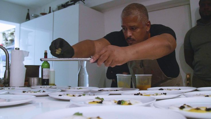 Dominican American chef Miguel Trinidad grinds a bud of cannabis from the "Headbanger" strain onto a plate of scallop crudo.