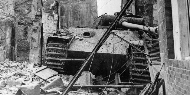 World War II, A German 'Tiger' tank destroyed, in the ruins of Argentan (Normandy), In the back, the cathedral, August 20, 1944. (Photo by Photo12/UIG/Getty Images)