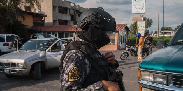 State Police elite group personnel patrol a street during a security operation in Jamay, Jalisco State Mexico, on September 30, 2016.Three more corpses were found on the banks of the Lerma River, near Lake Chapala raising the count to 13 bodies. / AFP / HECTOR GUERRERO (Photo credit should read HECTOR GUERRERO/AFP/Getty Images)