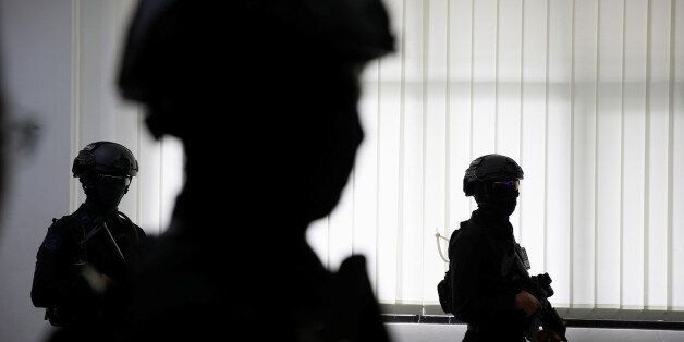 Anti-terror policemen stand at police headquarters in Jakarta, Indonesia, as police (not pictured) show the suspected militants who threw an explosive device at a Samarinda church, November 30, 2016. REUTERS/Beawiharta