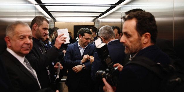 Alexis Tsipras, Greece's prime minister, centre, travels in an elevator between following a meeting at the World Economic Forum (WEF) in Davos, Switzerland, on Wednesday, Jan. 20, 2016. World leaders, influential executives, bankers and policy makers attend the 46th annual meeting of the World Economic Forum in Davos from Jan. 20 - 23. Photographer: Simon Dawson/Bloomberg via Getty Images
