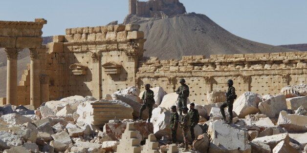 Syrian army soldiers stands on the ruins of the Temple of Bel in the historic city of Palmyra, in Homs Governorate, Syria in this April 1, 2016 file photo. The Fakhreddin's Castle is seen in the background. REUTERS/Omar Sanadiki/Files TPX IMAGES OF THE DAY