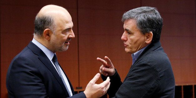 European Economic and Financial Affairs Commissioner Pierre Moscovici speaks to Greek Finance Minister Euclid Tsakalotos (R) during a euro zone finance ministers meeting in Brussels, Belgium December 5, 2016. REUTERS/Francois Lenoir