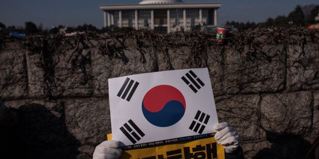 Protesters gather outside the National Assembly to demand the impeachment of South Korean President Park Geun-Hye, in Seoul on December 9, 2016South Korean lawmakers began voting on an impeachment motion to strip President Park Geun-Hye of her sweeping executive powers over a corruption scandal that has paralysed her administration and triggered massive street protests / AFP / Ed JONES (Photo credit should read ED JONES/AFP/Getty Images)