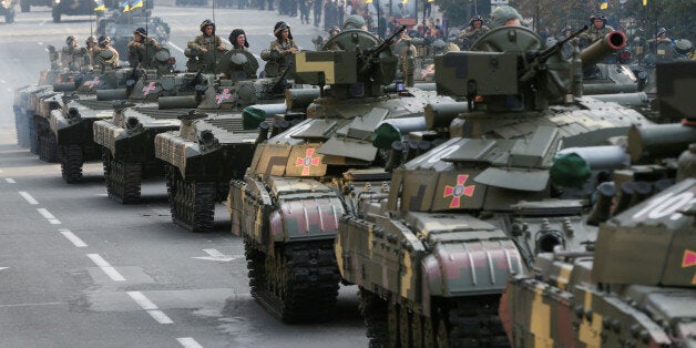 Ukrainian servicemen sit atop tanks and infantry fighting vehicles before a rehearsal for the Independence Day military parade in central Kiev, Ukraine, August 22, 2016. REUTERS/Valentyn Ogirenko