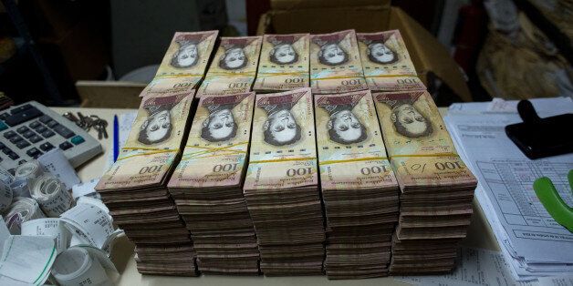 Stacks of banknotes sit on a desk inside the office of a bakery in Caracas, Venezuela, on Sunday, Oct. 16, 2016. Once one of the world's strongest currencies, the bolivar has been reduced to a nuisance. Basic purchases require hundreds of bills. The currency is so devalued and each purchase requires so many bills that instead of counting, businesses are weighing them. Photographer: Manaure Quintero/Bloomberg via Getty Images