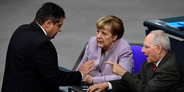 German Vice Chancellor, Economy and Energy Minister Sigmar Gabriel (L), German Chancellor Angela Merkel (C) and German Finance Minister Wolfgang Schaeuble talk during a session at the Bundestag (lower house of parliament) in Berlin on November 25, 2016, during a week of budget debate. / AFP / TOBIAS SCHWARZ (Photo credit should read TOBIAS SCHWARZ/AFP/Getty Images)
