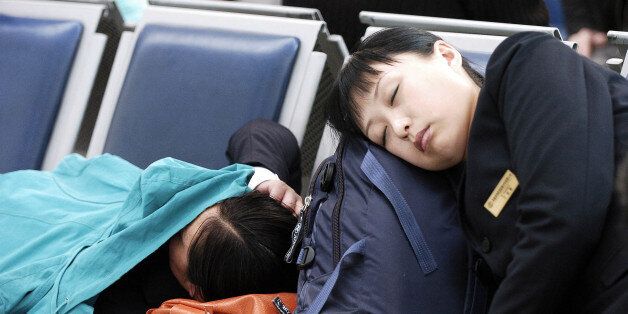 In this photo released by China's official Xinhua news agency, passengers fall asleep while waiting for their flight at Taoxian International Airport in Shenyang, northeast China's Liaoning province, on Tuesday March 6, 2007. The airport, which was closed in the morning of Sunday due to the heaviest snowstorm in 56 years, reopened Tuesday morning, Xinhua said. (AP Photo/Xinhua, Guo Dayue)