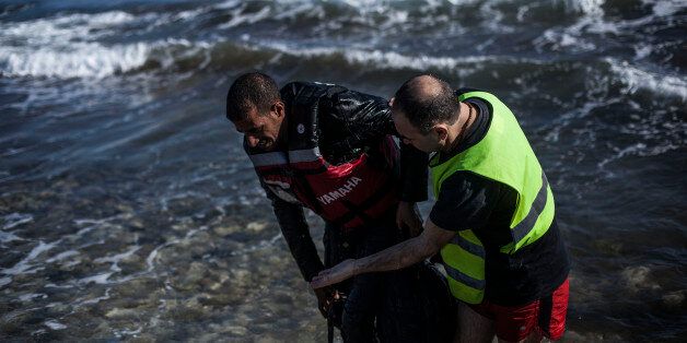 A volunteer, right, helps a Syrian refugee to get out of the sea after his arrival on the Greek northeastern island of Lesbos, Saturday, Feb. 20, 2016. EU leaders at a summit in Brussels made little headway in the elusive search for joint solutions to the influx of refugees and other migrants, though they did agree to hold a meeting in early March with Turkey. (AP Photo/Manu Brabo)