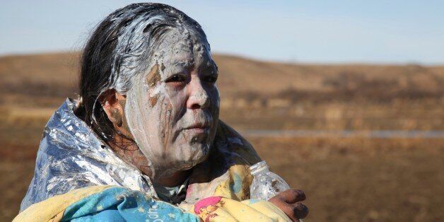 Tonya Stands recovers after being pepper sprayed by police after swimming across a creek with other protesters hoping to build a new camp to block construction of the Dakota Access Pipeline, near Cannon Ball, N.D., Wednesday, Nov. 2, 2016. Officers in riot gear clashed again Wednesday with protesters near the Dakota Access pipeline, hitting several dozen with pepper spray as they waded through waist-deep water in an attempt to reach property owned by the pipeline's developer. (AP Photo/John L. M