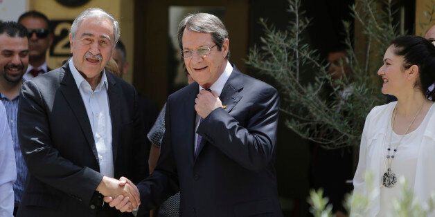 Cyprus' President Nicos Anasatsiades, right, and Turkish Cypriot leader Mustafa Akinci shake hands before they join the Greek and Turkish Cypriots children, inside the UN controlled buffer zone at Ledras palace crossing point in divided capital Nicosia in east Mediterranean island of Cyprus, Thursday, June, 2, 2016. Anastasiades and Akinci met with 100 fifth-grade Greek and Turkish Cypriot students - 50 from either community - to underscore their commitment to reaching an accord that will reunify the island. (AP Photo/Petros Karadjias)