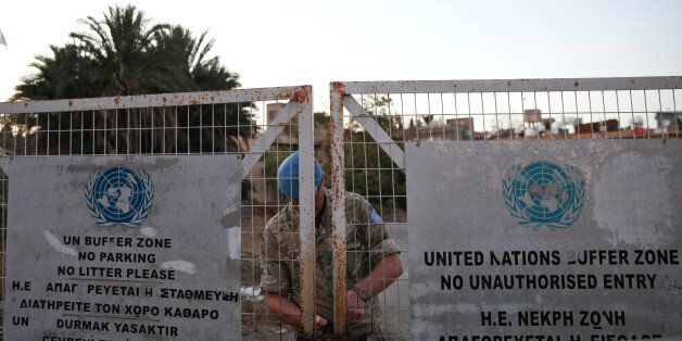 A U.N. soldier locks a gate inside the UN-controlled buffer zone in Nicosia, Cyprus November 7, 2016. REUTERS/Yiannis Kourtoglou